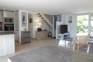 uma sala de estar com uma cozinha e uma sala de jantar em REF 123 Maison T5 pour huit personnes proche plage à Arzon em Arzon