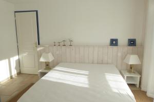 um quarto com uma grande cama branca e 2 candeeiros em REF 123 Maison T5 pour huit personnes proche plage à Arzon em Arzon