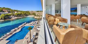 a hotel lobby with a view of the ocean and a pool at Globales Cala Viñas Adults Only 16+ in Cala Vinyes