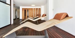 Una sala de estar con varias sillas sobre un suelo de madera. en Globales Cala Viñas Adults Only 16+, en Cala Vinyes