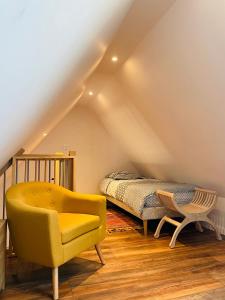 ein Schlafzimmer mit einem Bett und einem gelben Stuhl in der Unterkunft Le Courlis in Guimaëc