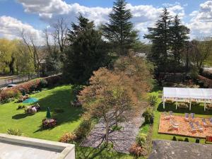 uma vista sobre um jardim com mesas e cadeiras em Best Western Plus Pinewood Manchester Airport-Wilmslow Hotel em Handforth