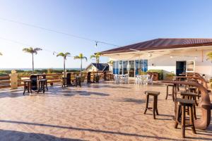 a patio with tables and chairs and palm trees at Ovemar Resort Hotel in Vigan