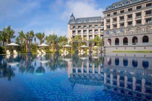 a building with a large pool of water in front of it at Wyndham Garden Haikou South in Haikou