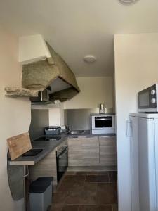 a kitchen with a stove and a refrigerator at Le Courlis in Guimaëc