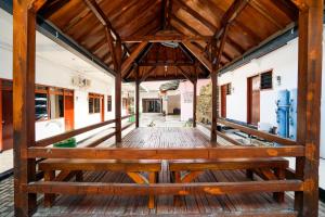 a wooden porch with a bench in a building at Merapi Inn Syariah by ecommerceloka in Surabaya