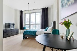 Schlafzimmer mit einem Bett, einem Tisch und einem Fenster in der Unterkunft Hilltop Apartments - Noblessner District in Tallinn