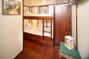 Kleines Zimmer mit einem Etagenbett und einem Spiegel in der Unterkunft Alexander von Humboldt - Das Schiff in Bremen