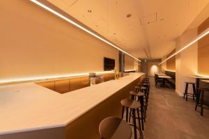 東京にあるThe Kanzashi Tokyo Asakusaのスツールのあるレストランのバー