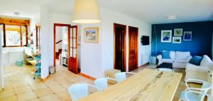 a living room with a wooden table and white chairs at Casa Las Vistas Llanes in Nueva de Llanes