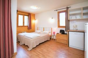 1 dormitorio con 2 camas y cocina con encimera en Le Hameau SPA & PISCINE studio 4pers by Alpvision Résidences, en Orelle