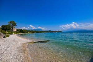 einen Strand mit klarem Wasser und felsiger Küste in der Unterkunft Apparthotel San Sivino in Manerba del Garda