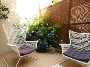 two wicker chairs sitting on a patio with blue flowers at Bela Vista - Lissabon Altstadt in Lisbon