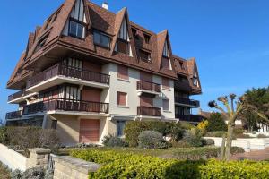 un gran edificio con techo de gambrel en Joli studio en front de mer - CABOURG, en Cabourg