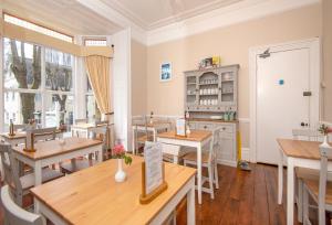 a restaurant with tables and chairs and a kitchen at The Pendennis Guest House in Penzance