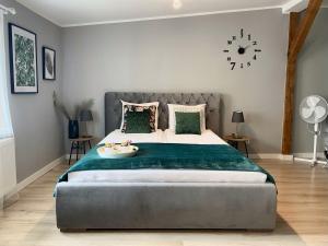 a bedroom with a large bed with a green blanket at Apartament Blue Lagoon in Sopot