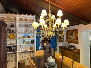 a dining room with a chandelier and a dining table at À-do-Zé-Velho in Sesimbra