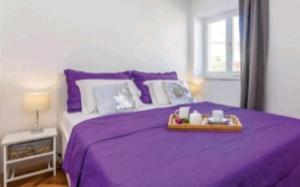 a purple bed with a tray on top of it at Villa deluxe "H" - private jacuzzi in Novi Vinodolski +30 photos