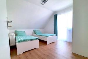 - un salon avec deux lits et une fenêtre dans l'établissement Theox Apartment No 2 Modernes Apartment zwischen Mannheim & Heidelberg, à Edingen-Neckarhausen
