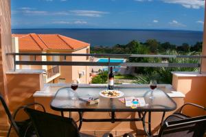 a table with a plate of food and two glasses of wine at Zephyros Hotel in Skala