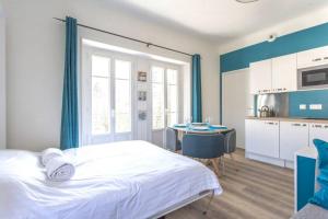a bedroom with a bed and a kitchen with a table at Zen Studio Les Thermes - Challes Centre - Parking in Challes-les-Eaux