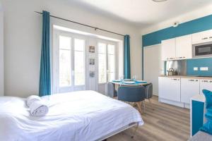 Cet appartement comprend une chambre avec un lit et une cuisine avec une table. dans l'établissement Zen Studio Les Thermes - Challes Centre - Parking, à Challes-les-Eaux