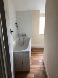 a bathroom with a tub with a shower in it at Hollybush cottage in Abergavenny