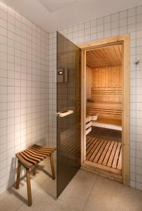 a sauna with a bench and a glass door at Antares Hotel in Gdynia