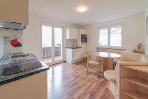 a kitchen and a living room with a table at Residence Ortlerhof in Prato allo Stelvio