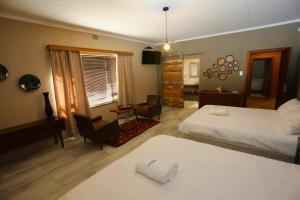 a hotel room with two beds and a living room at Prospectors Inn in Lüderitz +132 photos
