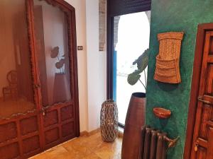 une chambre avec une porte et un vase à côté d'une fenêtre dans l'établissement Riad Mezquita de Cordoba, à Cordoue