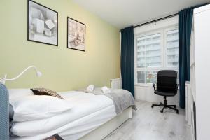 a bedroom with a bed and a chair and a window at Business Apartments Warsaw Mokotów in Warsaw