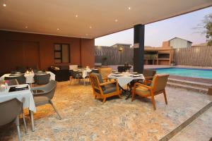a restaurant with tables and chairs and a pool at Prospectors Inn in Lüderitz