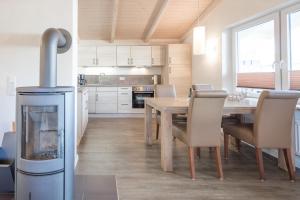eine Küche und ein Esszimmer mit einem Tisch und einem Kamin in der Unterkunft Ferienhaus Süderoog in Dagebüll
