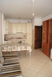 Appartamento a Andora في مارينا دا اندورا: مطبخ مع طاولة وكراسي في غرفة