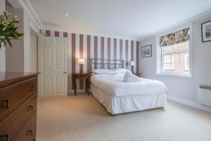um quarto branco com uma cama e uma janela em St Helen's House with Minster views em York