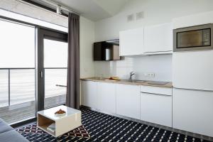 a kitchen with white cabinets and a table at Boulevard Ustronie Morskie by Zdrojowa in Ustronie Morskie