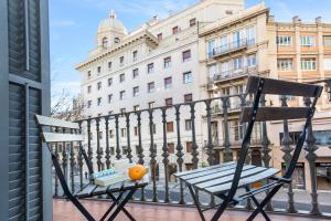 an orange sitting on a chair on a balcony at Stay U-nique Apartments Balmes in Barcelona