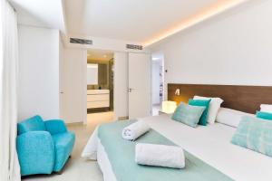 a bedroom with a large bed and a blue chair at Villa Magdala in Portopetro +40 photos