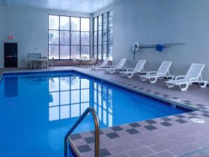 a swimming pool with lounge chairs and a swimming pool at Sleep Inn in Antigo