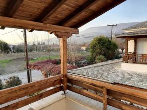 a wooden deck with a view of a house at Harmony seaside apartments in Koropi