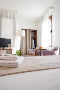 Habitación blanca con cama y sala de estar. en U-Sense Sevilla Centro, en Sevilla