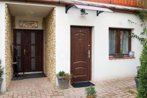 a house with two brown doors on it at Szépasszony Fogadó in Eger