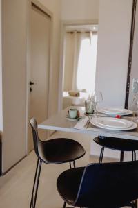 uma mesa branca com duas cadeiras e uma mesa com pratos em Le Beach em Saint-Tropez