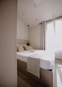 a bedroom with a white bed and a window at Le Beach in Saint-Tropez