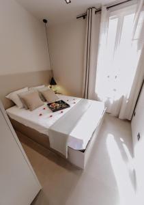 a white bedroom with a bed with a book on it at Le Beach in Saint-Tropez