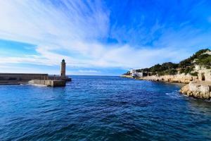 a lighthouse in the middle of a large body of water at LE RAVISSANT - 50m du Port - très calme in Cassis