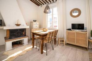 uma sala de jantar com uma mesa e uma lareira em LE RAVISSANT - 50m du Port - très calme em Cassis