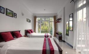 um quarto com 2 camas e uma janela em De Paris à Kandy em Kandy