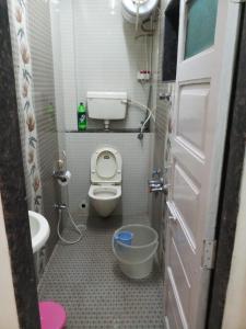 a small bathroom with a toilet and a sink at Vamoose Swara Niwas Bungalow in Mahabaleshwar